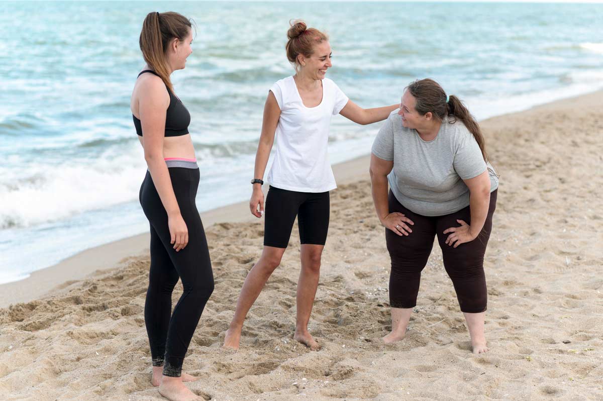 three women running on a beach taking a break encouraging teamwork and community at Capistrano Beach Recovery