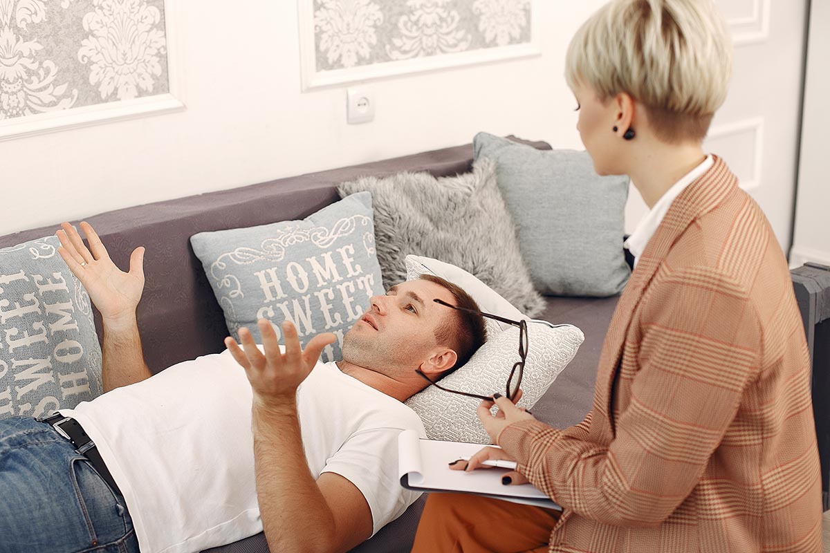Man in therapy session discussing personal struggles with a professional counselor during a 12-step addiction recovery program at Capistrano Beach Recovery