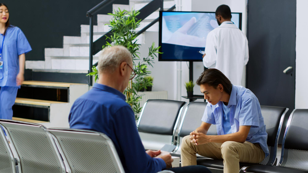 Two men waiting in a medical facility lobby, representing the compassionate and professional care available through Cigna insurance coverage at Capistrano Beach Recovery.