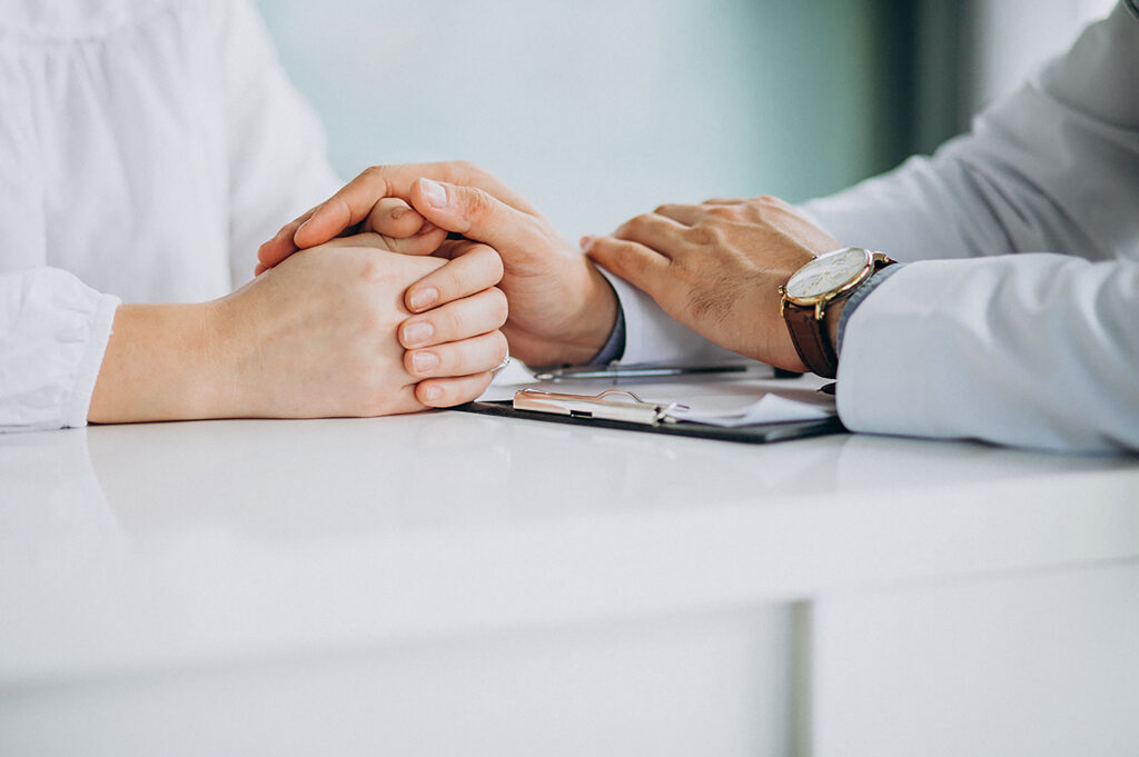 Can I Do Outpatient Mental Health Therapy? 2 Therapist offering emotional support by holding a patient’s hands during an outpatient mental health therapy session at Capo Beach Recovery in San Juan Capistrano, California.