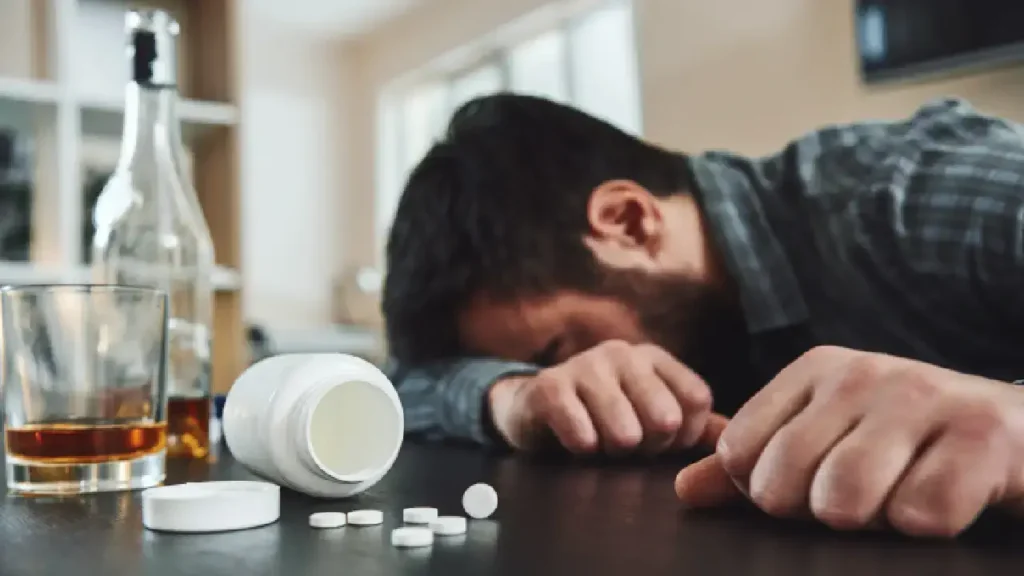 Is the T257 White Pill Addictive? Risks of Misuse and Dependence 6 Man passed out next to pills and alcohol bottle, depicting the dangers of substance misuse and the importance of treatment for addiction at Capo Beach Recovery in San Juan Capistrano, California.