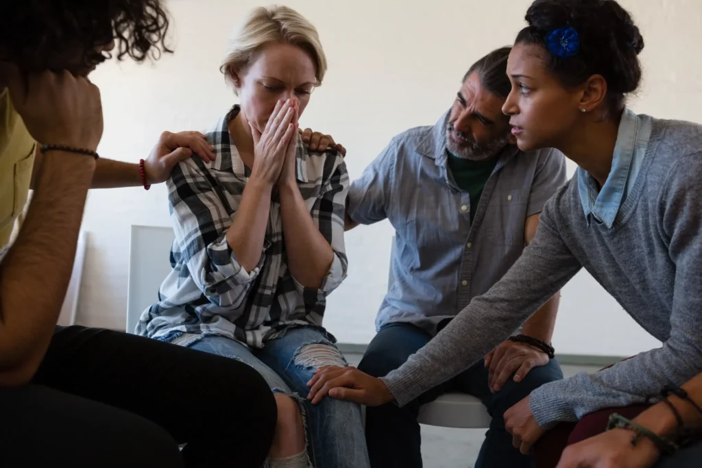 Support group comforting a woman during an emotional moment at Capo Beach Recovery in San Juan Capistrano, California, showing empathy and healing in addiction recovery.