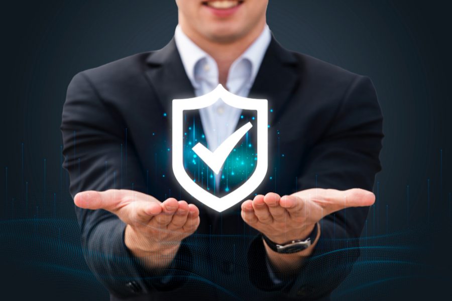 Business professional holding a glowing shield with a check mark symbolizing secure Cigna insurance coverage for addiction treatment at Capistrano Beach Recovery.